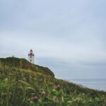 Spokojna scena latarni morskiej na trawiastym klifie przybrzeżnym w Kanadzie.