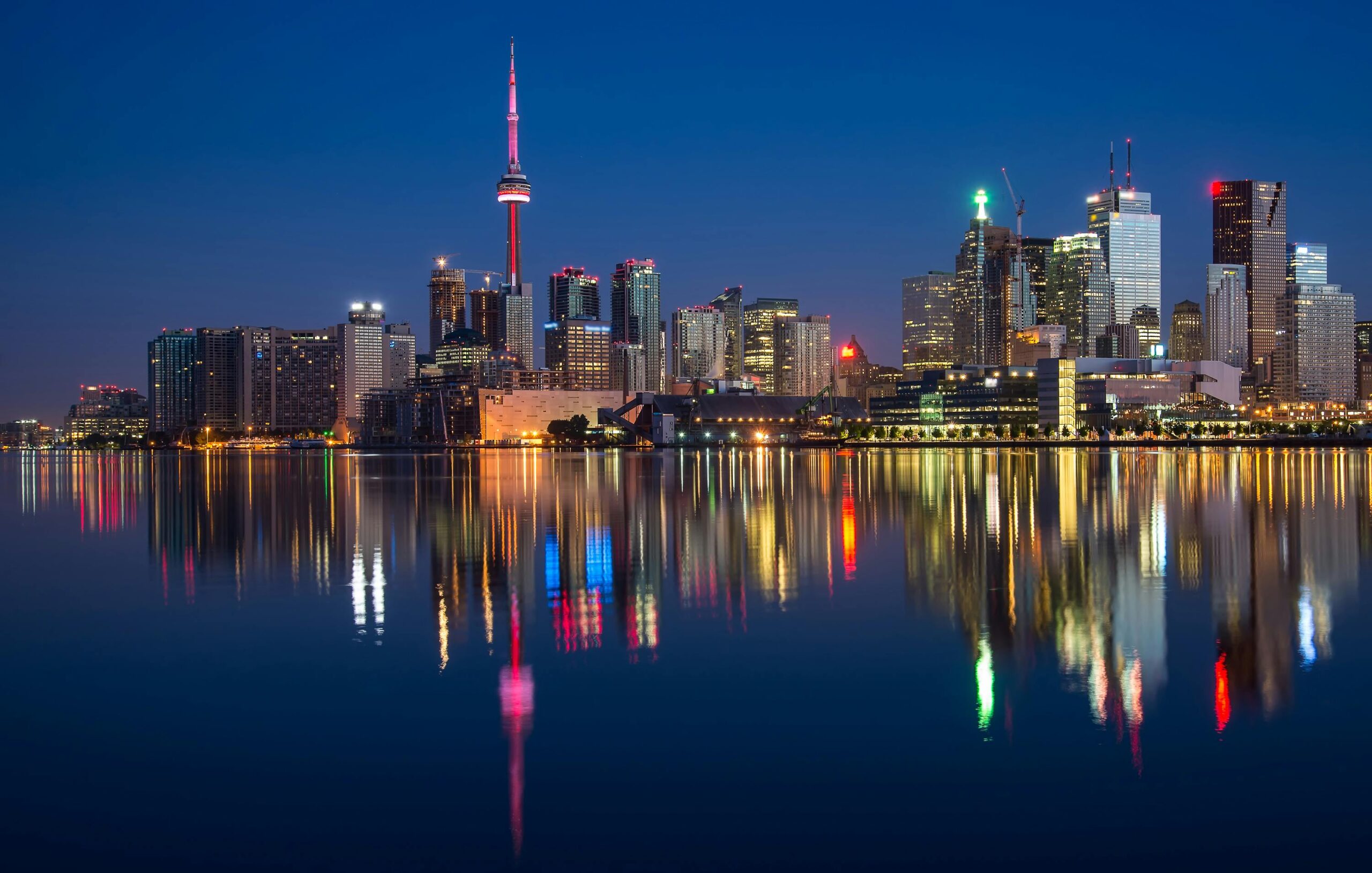 Oszałamiający nocny widok na panoramę Toronto odbijającą się w wodzie z widoczną wieżą CN.