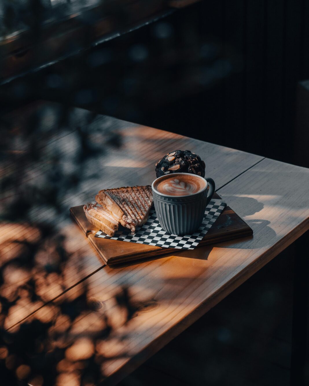 Ciepła aranżacja z cappuccino i tostami na drewnianym stole, idealna na przytulną atmosferę poranka.