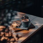 Ciepła aranżacja z cappuccino i tostami na drewnianym stole, idealna na przytulną atmosferę poranka.