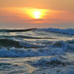 Żywy zachód słońca nad falami oceanu na chilijskim wybrzeżu, ukazujący piękny krajobraz morski.