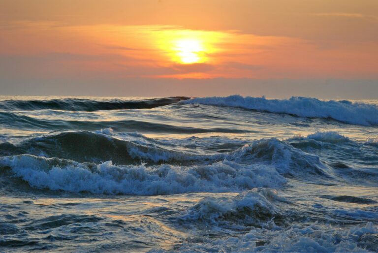 Żywy zachód słońca nad falami oceanu na chilijskim wybrzeżu, ukazujący piękny krajobraz morski.