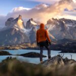 Szlak Narodowy Szósty Region: Wędrówki po rzece Cachapoal Turysta stoi o wschodzie słońca w Torres del Paine w Chile, z widokiem na majestatyczne góry i spokojne jezioro.