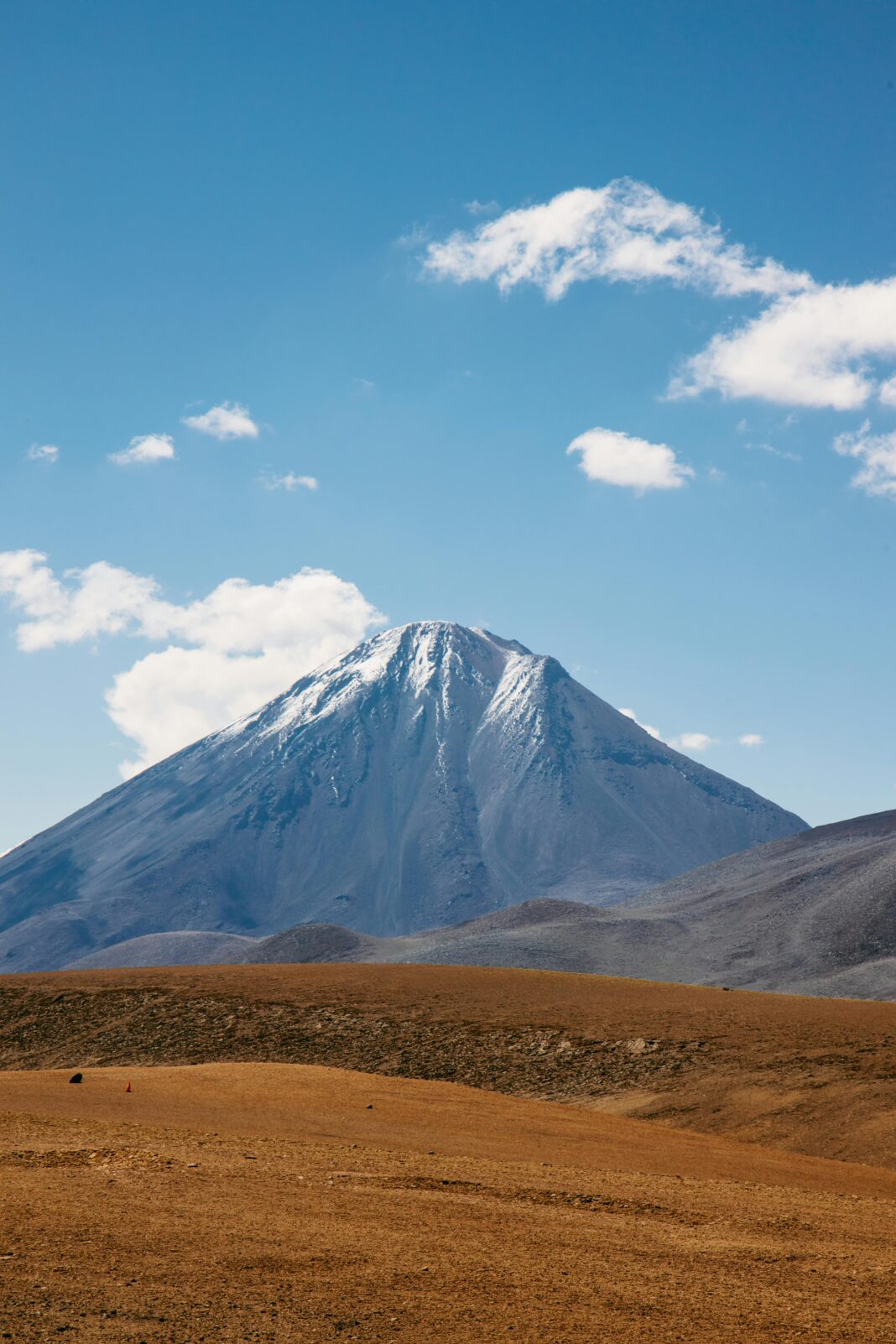 Majestatyczna pokryta śniegiem góra pod jasnym błękitnym niebem w Chile.