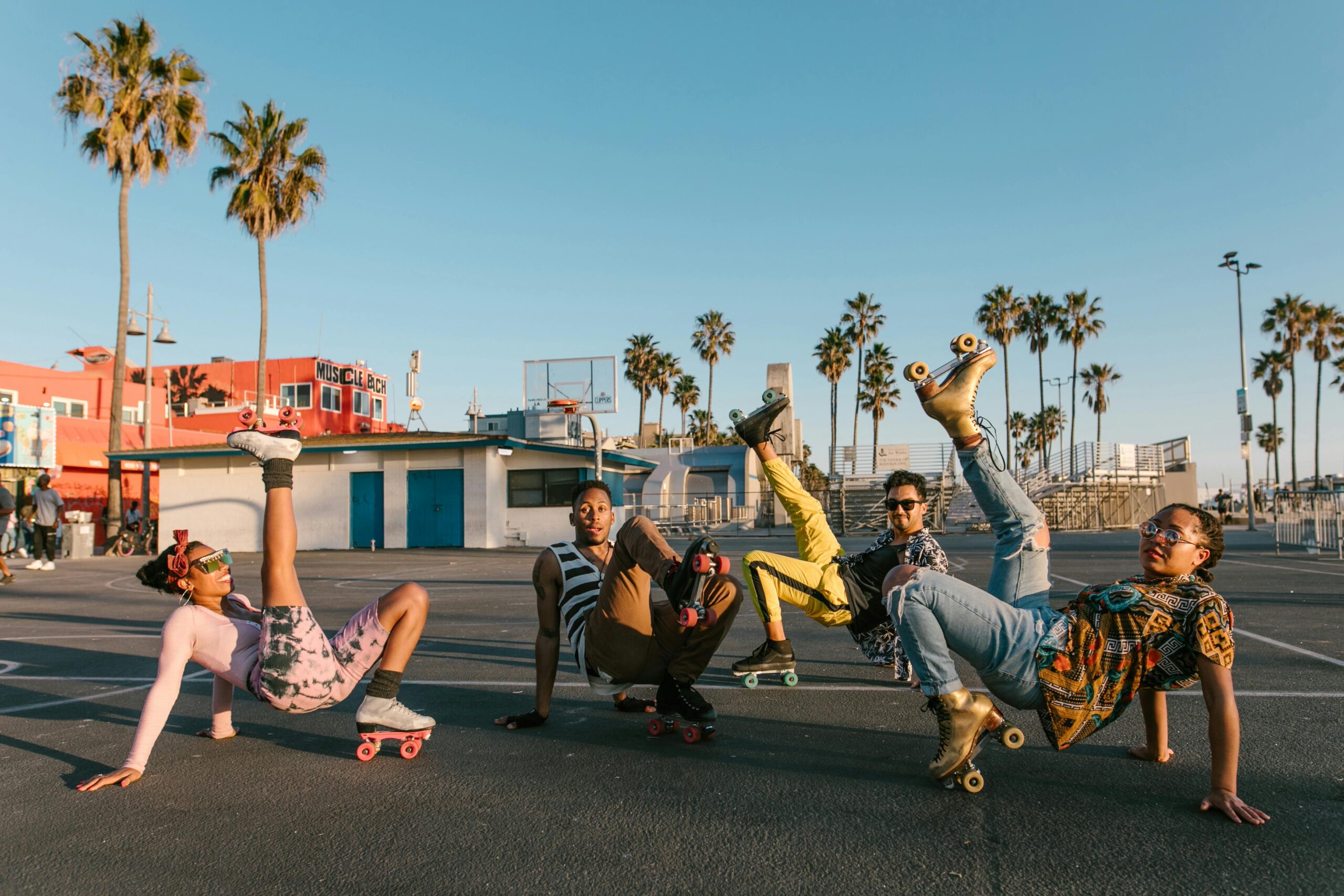 Grupa tętniących życiem przyjaciół lubi jeździć na rolkach w Venice Beach pod słonecznym niebem.