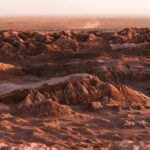 Oszałamiający widok z lotu ptaka na opuszczony pustynny krajobraz z nierównym terenem o zachodzie słońca.