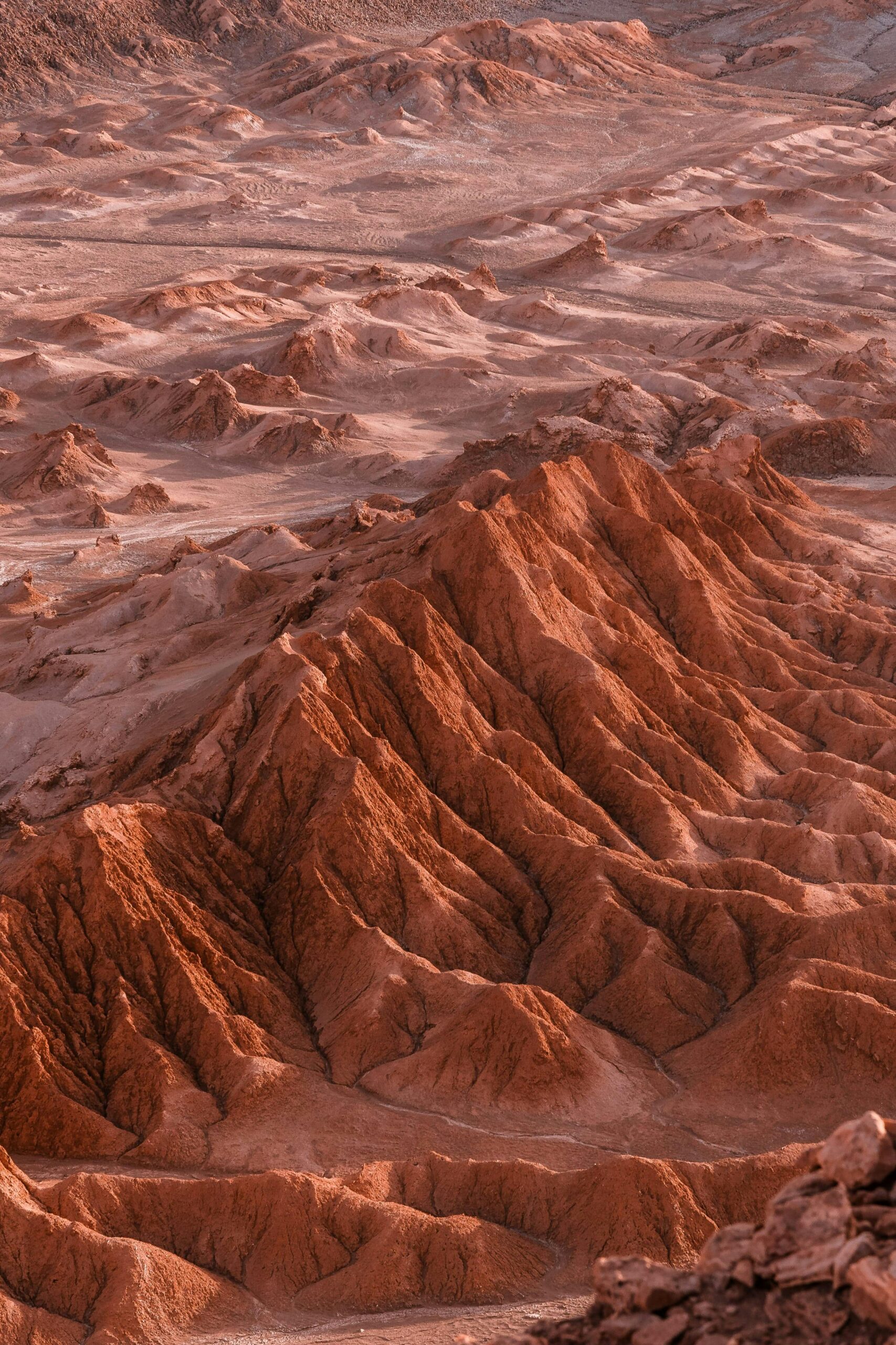 Poznaj zawiłe wzory pustynnych wydm i gór na tym zapierającym dech w piersiach zdjęciu lotniczym.