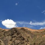 Malowniczy widok na starożytną ścianę na skalistym wzgórzu pod tętniącym życiem błękitnym niebem z chmurami.