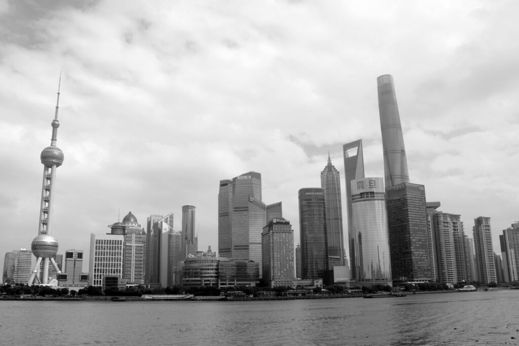Dramatyczna czarno-biała panorama nowoczesnej dzielnicy Pudong w Szanghaju z kultowymi drapaczami chmur.