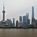 Oszałamiający widok na nowoczesną panoramę Szanghaju z kultową wieżą Perły Orientu po drugiej stronie nabrzeża.