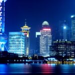 Oświetlona panorama Szanghaju z Wieżą Perły Orientu i miejskim pejzażem nocą.