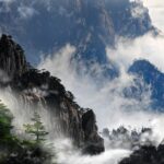 Mgliste szczyty górskie Huangshan w Chinach spowite mgłą, tworząc spokojny i dramatyczny krajobraz.