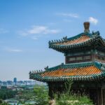 Wulkaniczne wyspy Hainan: Tropikalny raj w Chinach Tradycyjny pawilon w Pekinie z widoczną panoramą miasta pod czystym, błękitnym niebem.