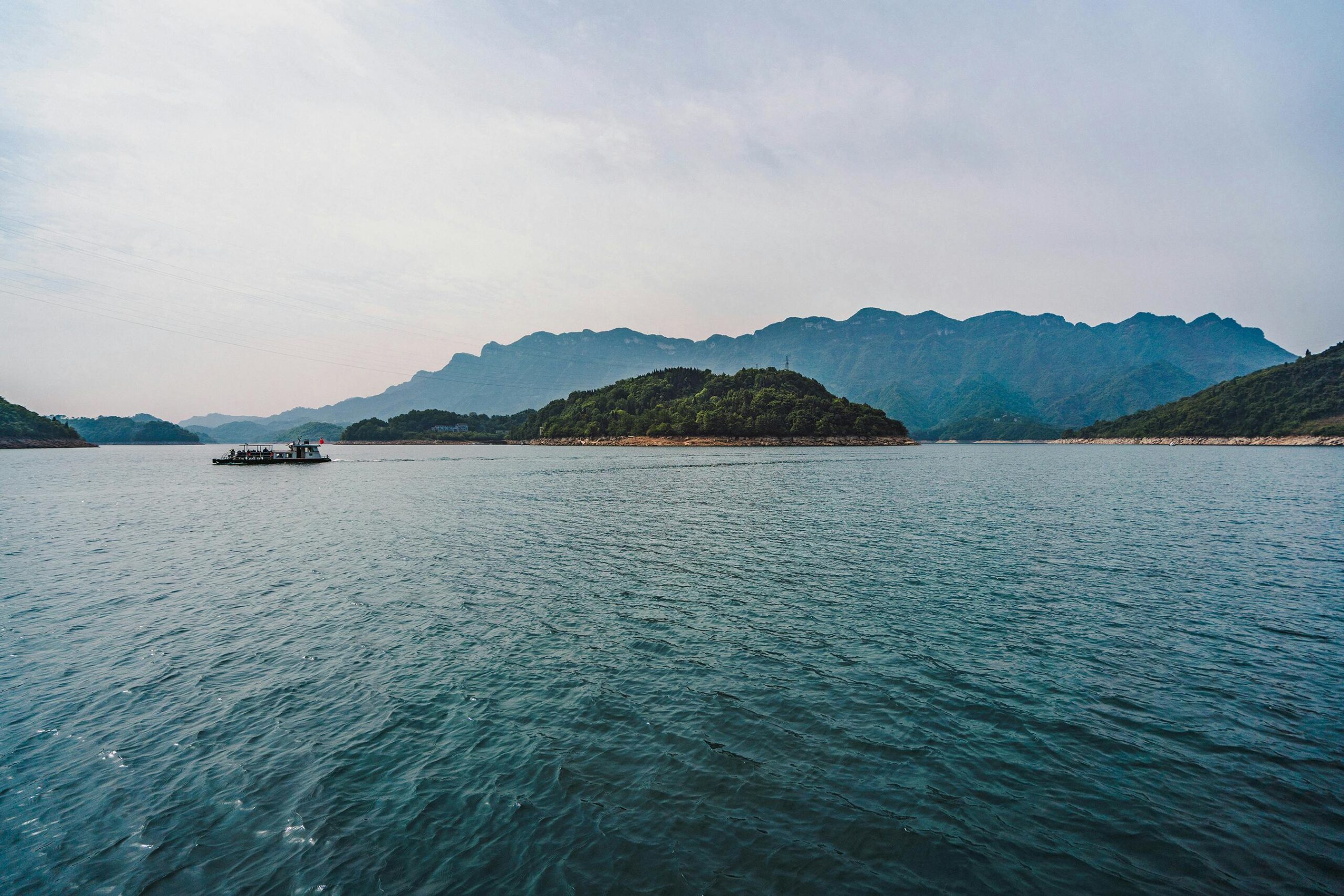Zapierający dech w piersiach widok na spokojne jezioro na tle gór w Hubei w Chinach, idealny dla miłośników podróży.