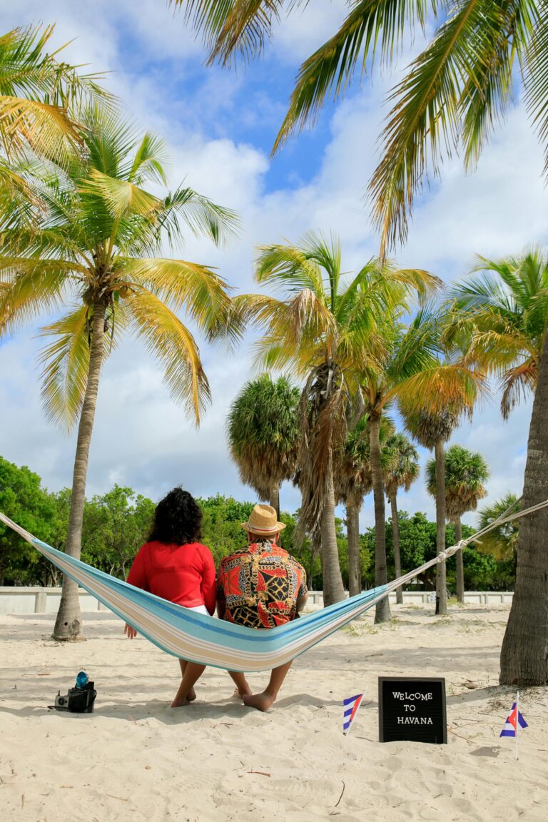 Para cieszy się spokojną chwilą na hamaku pod palmami na słonecznej plaży w Hawanie.