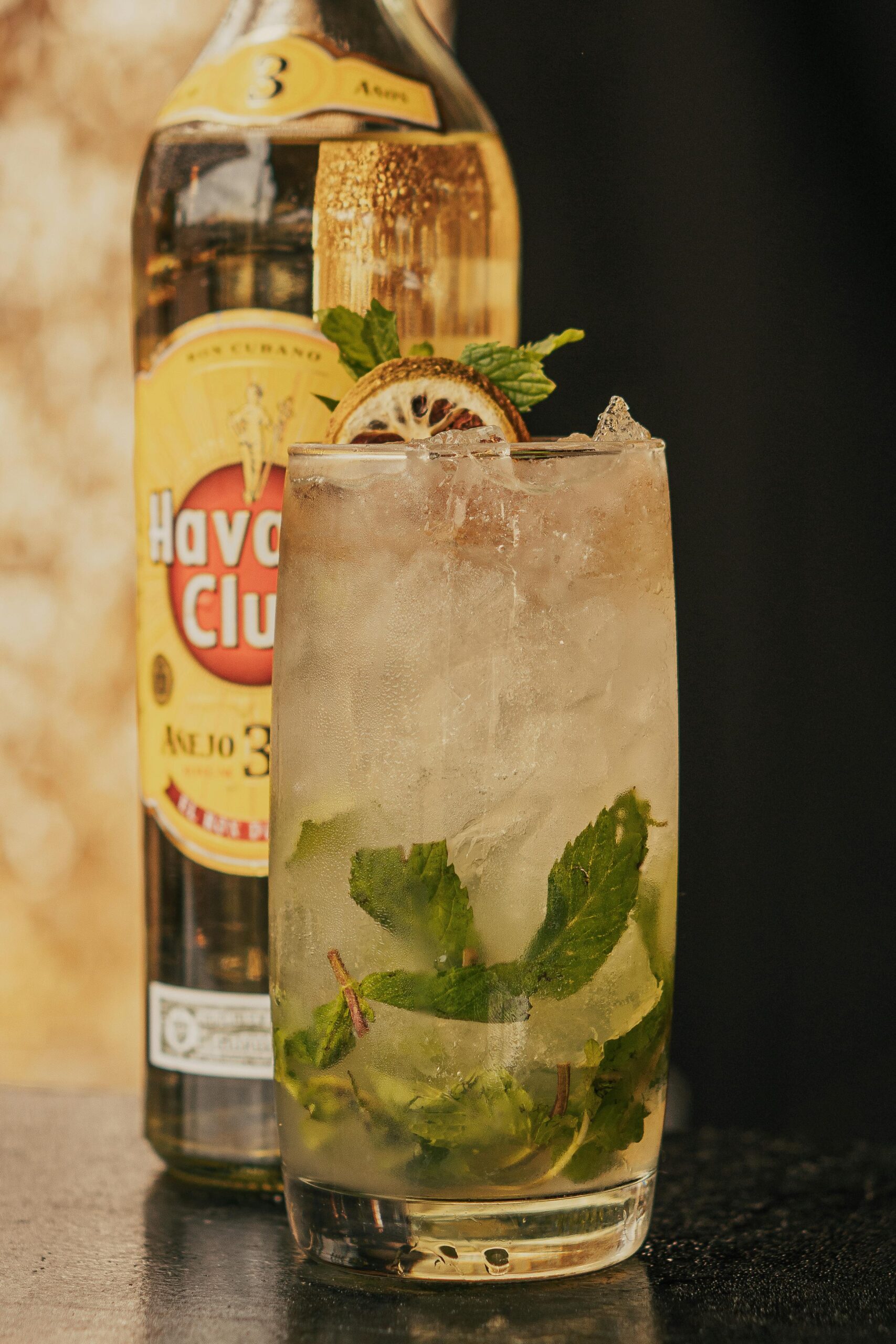 Zbliżenie orzeźwiającego koktajlu mojito z miętą i limonką przed butelką Havana Club.