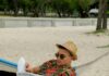 Mężczyzna czyta gazetę w hamaku na plaży w Hawanie, promując Miesiąc Świadomości Autyzmu.