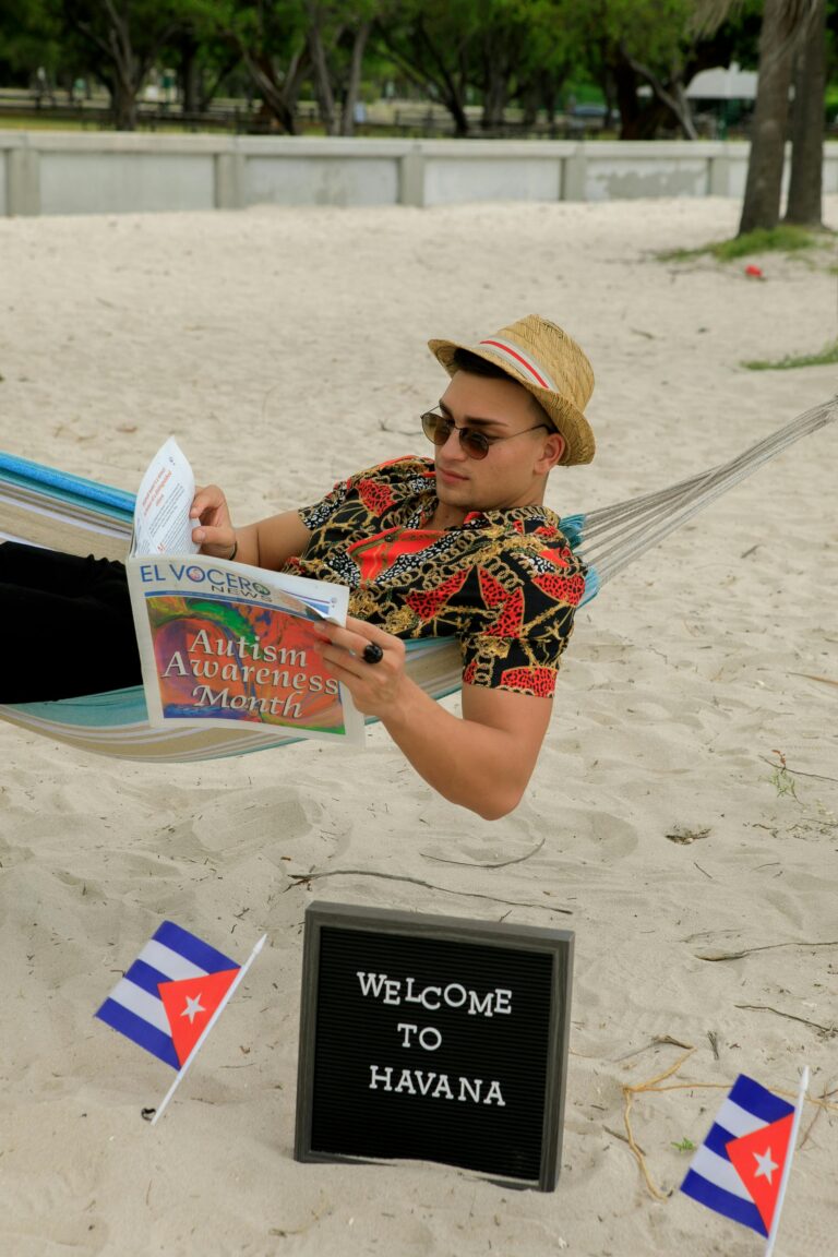 Mężczyzna czyta gazetę w hamaku na plaży w Hawanie, promując Miesiąc Świadomości Autyzmu.