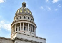 Trinidad – kolonialna perełka Kuby wpisana na listę UNESCO Klasyczny żółty samochód przejeżdżający obok El Capitolio w Hawanie na Kubie, z czystym błękitnym niebem.