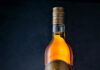Zbliżenie: butelka rumu Havana Club z kieliszkiem na powierzchni drewnianej.
