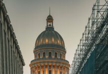 Dlaczego samochody na Kubie są tak wyjątkowe? Klasyczny zabytkowy samochód przed El Capitolio w Hawanie o zmierzchu z rusztowaniami na ulicy.