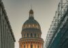 Klasyczny zabytkowy samochód przed El Capitolio w Hawanie o zmierzchu z rusztowaniami na ulicy.