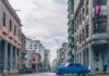 Urzekająca scena miejska w Hawanie z zabytkową architekturą i klasycznym niebieskim samochodem pod czystym niebem.