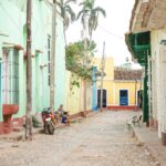 Urocza brukowana ulica z kolorowymi domami i palmami w kubańskim miasteczku.