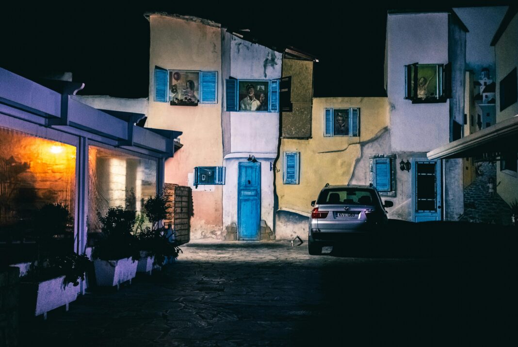 cypr Niesamowita scena miejska z kolorowymi fasadami i zaparkowanym samochodem w nocy.