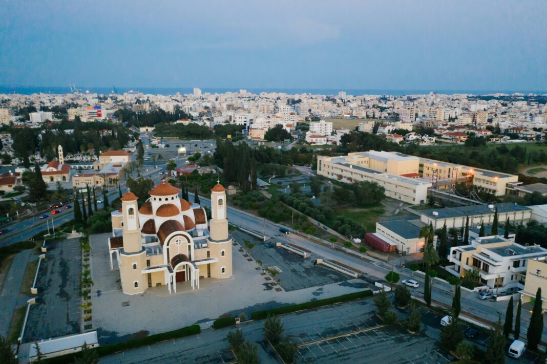 Ujęcie drona kościoła św. Jerzego Kontosa w Larnace na Cyprze, na tle pejzażu miejskiego.