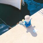 Scena morska z liną przywiązaną do słupka dokowego, niebieska woda w świetle słonecznym.