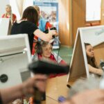 Velké Pavlovice – Festiwal Otwartych Piwnic Winiarskich Starsza kobieta uśmiecha się podczas sesji stylizacyjnej w tętniącym życiem salonie fryzjerskim w Karwinie.