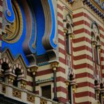 Kolorowa pasiasta fasada zabytkowej synagogi ze skomplikowanymi detalami.