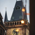 Urzekający obraz kultowej praskiej wieży zegarowej z ciepłymi wieczornymi światłami.