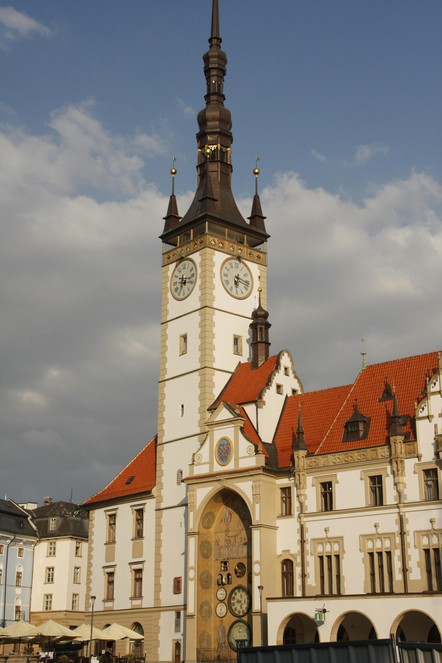 Gotycka wieża zegarowa ratusza w Ołomuńcu pod zachmurzonym niebem, ukazująca piękno architektury.