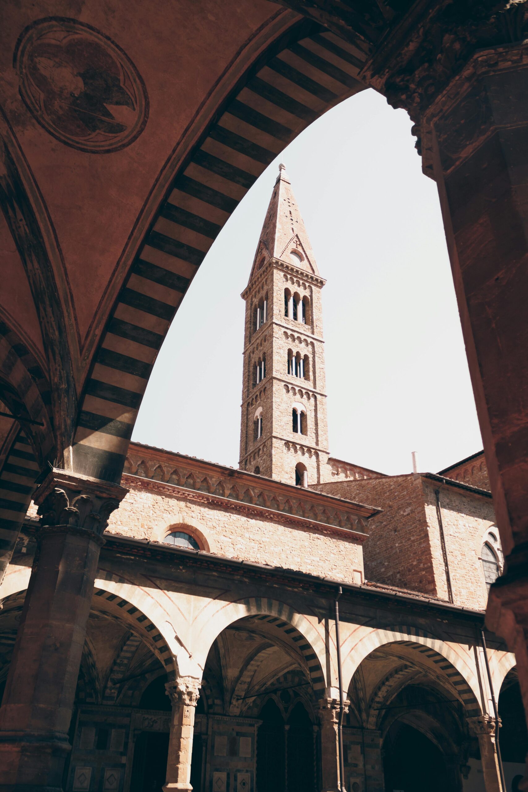 Widok na dzwonnicę Santa Maria Novella we Florencji przedstawiającą architekturę gotycką i romańską.