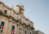 Niski kąt widzenia historycznej architektury kolonialnej z flagą w Santo Domingo.