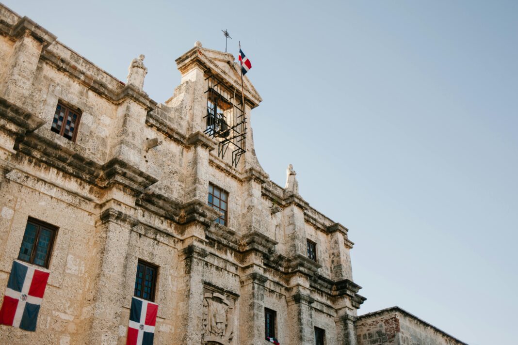 Niski kąt widzenia historycznej architektury kolonialnej z flagą w Santo Domingo.