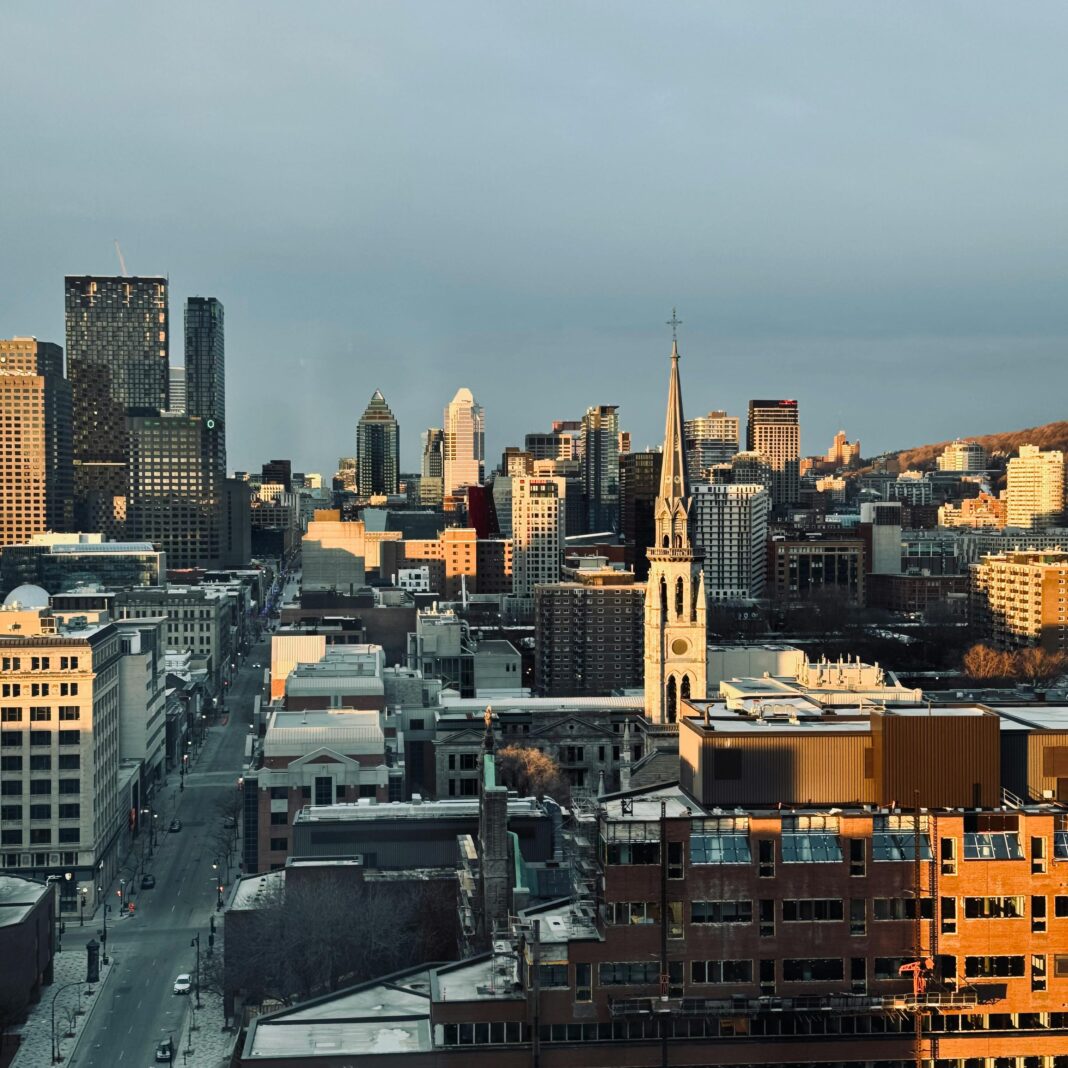 Widok z lotu ptaka na panoramę miasta Montreal z zabytkową wieżą kościoła o zachodzie słońca.