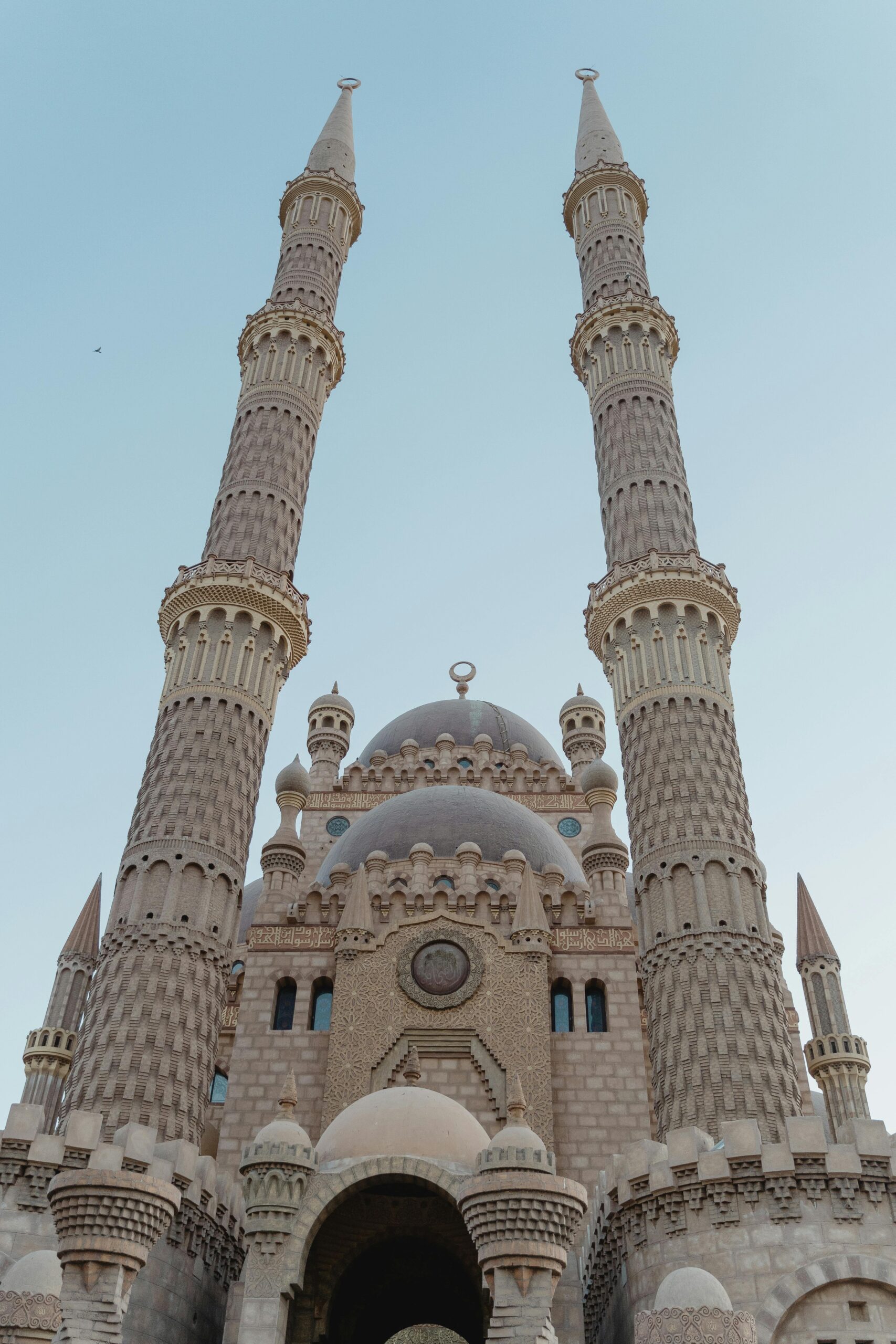 Oszałamiający meczet z bliźniaczymi minaretami sięgającymi nieba, ukazujący misterną architekturę.