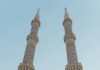 Oszałamiający meczet z bliźniaczymi minaretami sięgającymi nieba, ukazujący misterną architekturę.