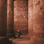 Najlepszy czas na wakacje w Egipcie – miesiąc po miesiącu Turysta zwiedzający misternie rzeźbione kolumny świątyni Dendera w Egipcie.