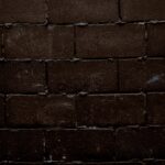 Tena: Brama do ekwadorskiej Amazonii i spływy raftingowe Zbliżenie tekstury ciemnego, szorstkiego muru, idealnego do tła.