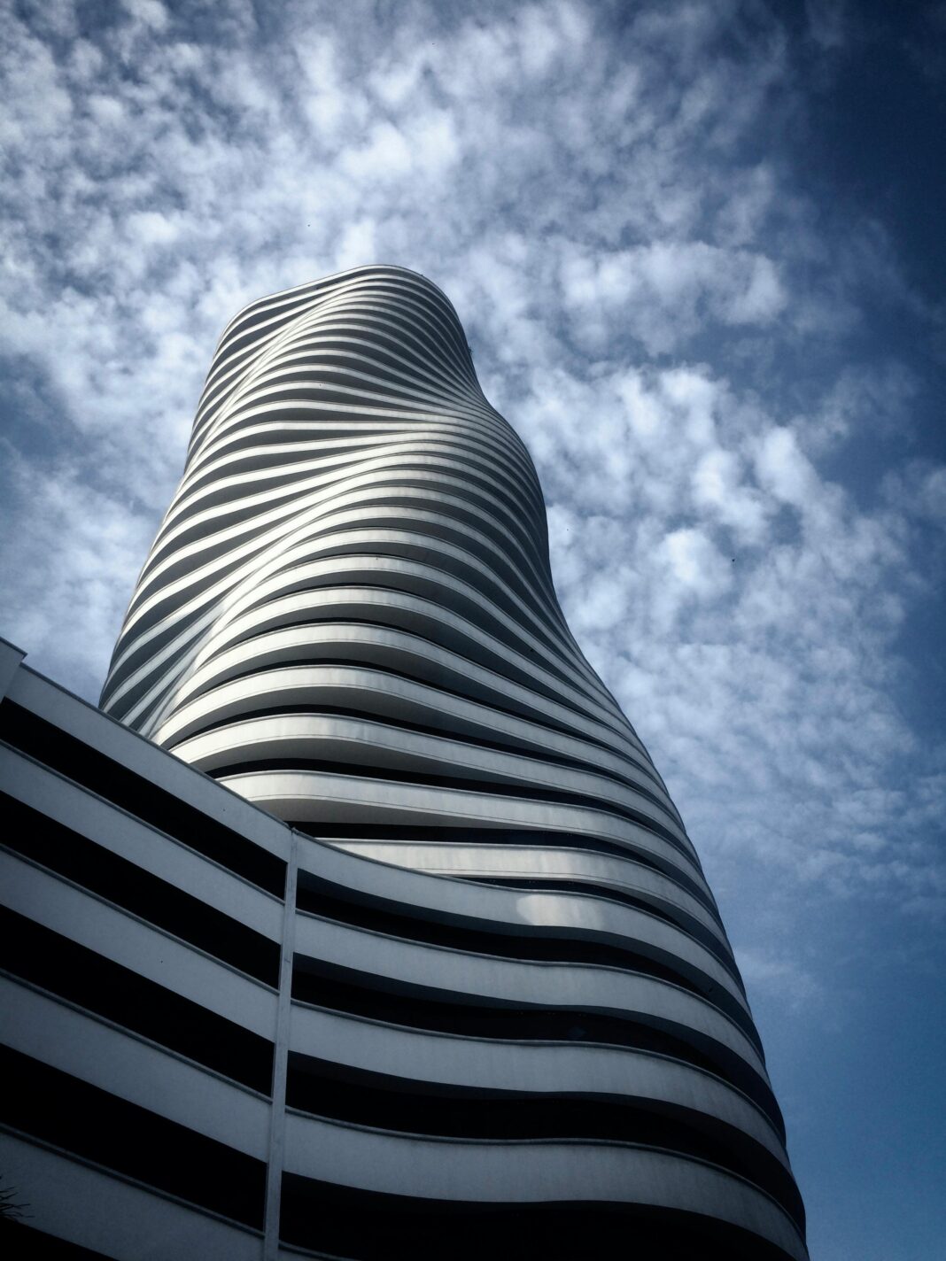 Uderzający projekt architektoniczny nowoczesnego drapacza chmur w Guayaquil uchwycony pod tętniącym życiem niebem.