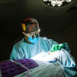 Skoncentrowany chirurg wykonujący plastykę nosa w jasnym świetle chirurgicznym w sterylnej sali operacyjnej.