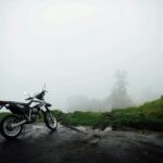 Motocykl zaparkowany na mglistej drodze w Ekwadorze, uchwycił tajemniczą atmosferę.