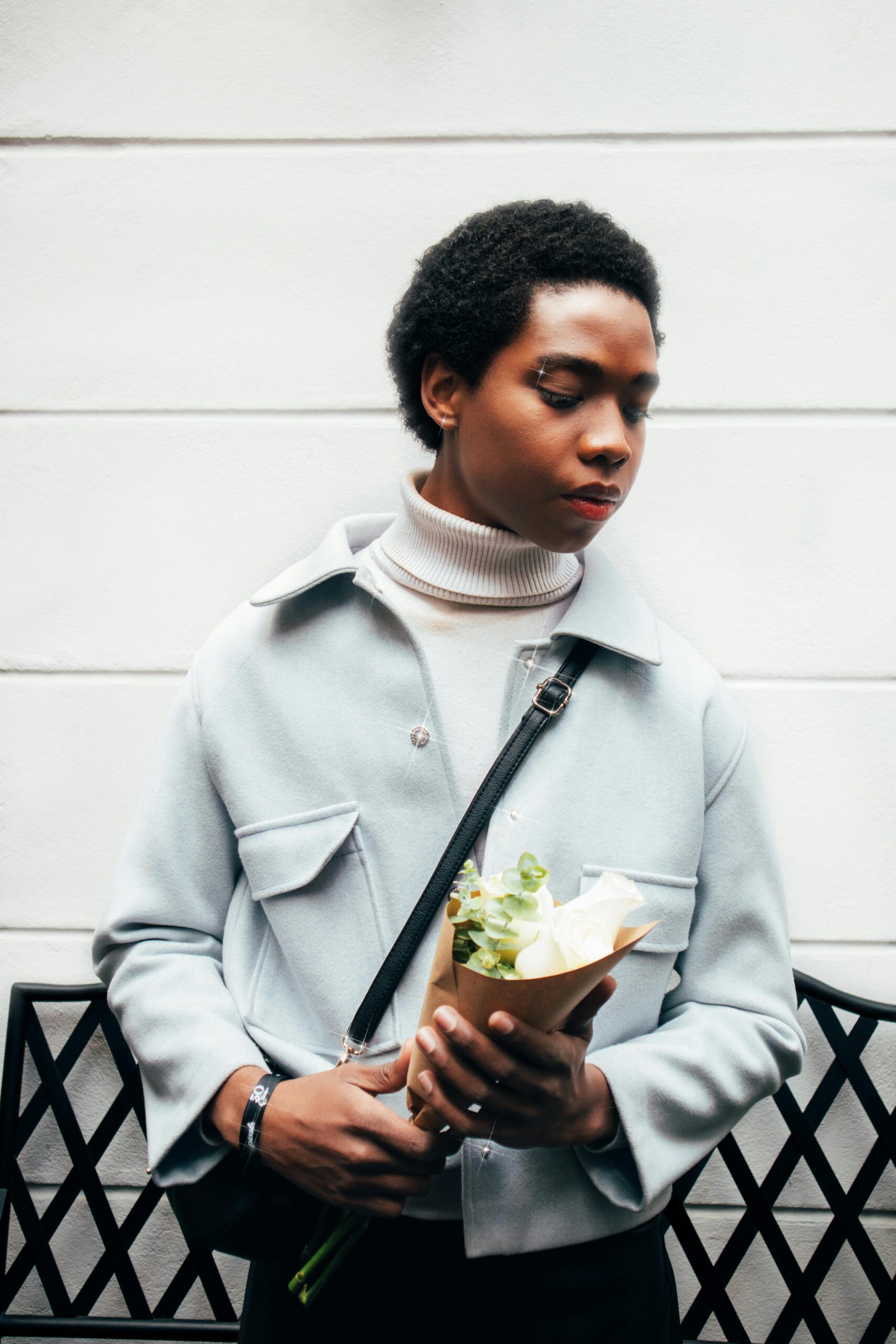 Portret stylowej osoby trzymającej kwiaty na nowoczesnym tle w Cuenca w Ekwadorze.