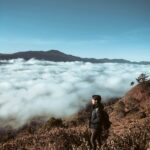 Mężczyzna wędrujący z plecakiem po górach w Sagada na Filipinach, pod czystym niebem.