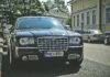Elegancki czarny samochód zaparkowany na słonecznej ulicy w Hamina w Finlandii, prezentujący luksus i elegancję.