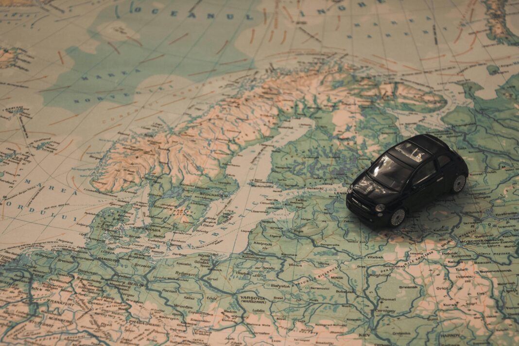 finlandia Miniaturowy czarny samochód na szczegółowej mapie Skandynawii, symbolizujący podróżnicze przygody.
